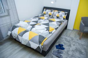 um quarto com uma cama e sapatos azuis no chão em Apartment Studio TEO - Near Everywhere You Want to Be em Subotica