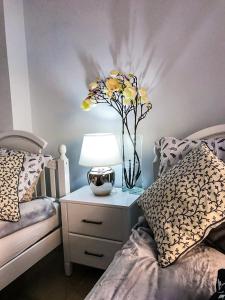 マニルバにあるCoto Real Duquesa Kiznos 411 Manilvaのベッドルーム1室(ベッド2台付)、黄色い花の花瓶1枚