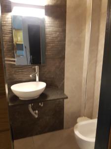 a bathroom with a white sink and a mirror at City Villa -amazing view in Alepou +22 photos