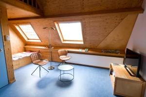 een kamer met 2 stoelen, een tafel en een tv bij B&B Molenstraat in Den Burg