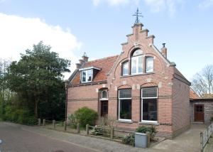 un edificio di mattoni con una croce sopra di B&B Molenstraat a Den Burg