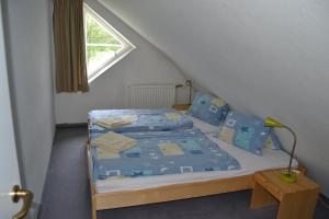 um quarto com uma cama com lençóis azuis e uma janela em Apartmány Holiday Pec em Pec pod Sněžkou