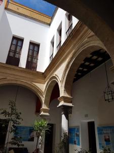 a building with arches in a courtyard with plants at Casa del Regidor in El Puerto de Santa María