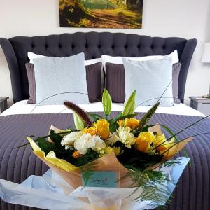 een dienblad met een boeket bloemen op een bed bij The Moorhead Bed & Breakfast in Wem