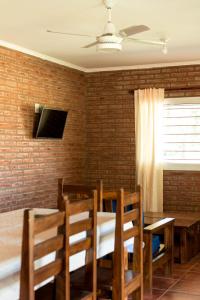 - une salle à manger avec une table, des chaises et une télévision dans l'établissement Cabañas La Luisa, à San José del Rincón