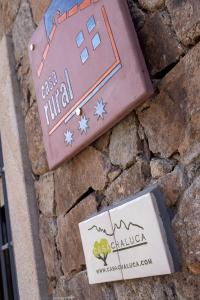 un edificio con un cartel en una pared de piedra en Casa Chaluca en La Aldehuela