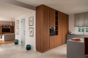 a kitchen with wooden cabinets and a living room at Villa Zara in Vabriga