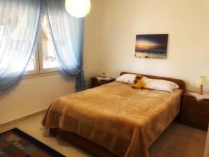 una camera da letto con un orsacchiotto seduto su un letto di The Hillhouse near Alexandroupolis ,Daphnee Apartment a Alexandroupoli