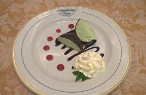 a white plate with a piece of cake and whipped cream at Albergo Stella Alpina in Molveno +63 photos