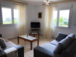 a living room with a couch and a coffee table at The Hillhouse near Alexandroupolis ,Daphnee Apartment in Alexandroupoli
