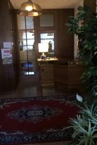 a hallway with a room with a desk and a rug at Albergo Stella Alpina in Molveno