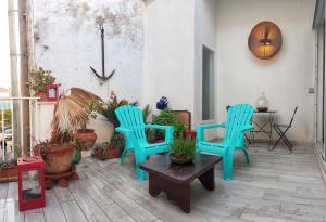 eine Terrasse mit zwei blauen Stühlen und einem Tisch in der Unterkunft Da Giovanna a Marzamemi in Marzamemi