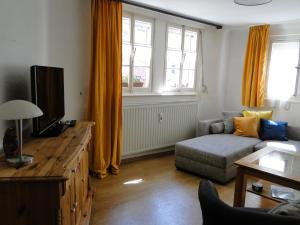 a living room with a couch and a tv at Altes Spitzhaus an der Goldroul in Senheim