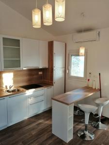 Una cocina con gabinetes blancos y una encimera de madera. en House Anica, en Starigrad-Paklenica