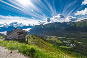 a house on a hill with mountains in the background at Alyeska Resort in Girdwood