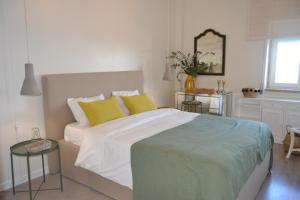 a bedroom with a large bed with yellow pillows at Campo De Ourique River View in Lisbon