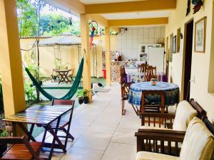 un patio con mesa, sillas y hamaca en Pousada Flor de Gaia, en Guarujá