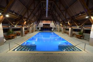 a large swimming pool in a building with tables and chairs at Alyeska Resort in Girdwood