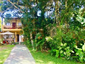 una casa con una pasarela delante de ella en Pousada Flor de Gaia, en Guarujá