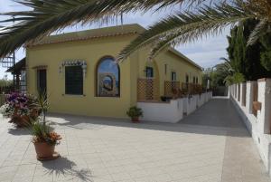 a yellow building with plants in front of it at Albergo Belvedere in Ventotene