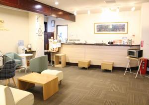 a waiting room with a counter and tables and chairs at Hotel Sunshine Iwaki in Iwaki