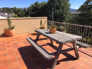 a wooden bench sitting on top of a patio at Kookaburra Lodge in Jindabyne