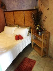 een slaapkamer met een bed met twee rode schoenen erop bij Shanti Lodge in Bangkok