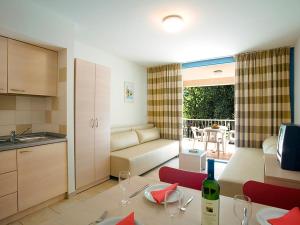 uma cozinha e sala de estar com uma mesa com copos de vinho em FKK Solaris Camping Resort by Valamar em Porec