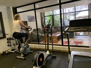 a woman riding a exercise bike in a gym at Hotel Middle Path & Spa in Pokhara
