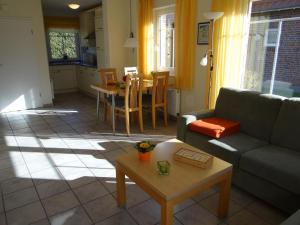 ein Wohnzimmer mit einem Sofa und einem Tisch in der Unterkunft 50102 Sonnenwind 2 in Carolinensiel