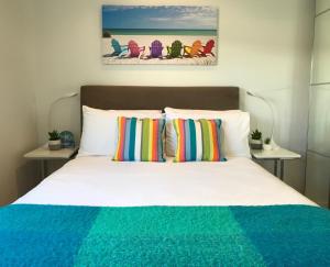a bedroom with a bed with colorful pillows at Cottesloe Beachfront Ocean View Apartment in Perth