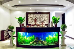 two people standing behind a fish tank in a room at D&G Villas Nusa Dua in Nusa Dua