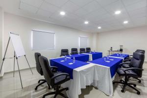 Sleep Inn Mexicali في مكسيكالي: قاعة المؤتمرات مع طاولة وكراسي زرقاء