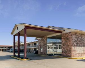 - un bâtiment en briques avec un auvent dans un parking dans l'établissement Econo Lodge Russellville I-40, à Russellville