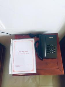 um telefone e um livro sobre uma mesa em Hotel Mỹ Anh em Sa Ðéc