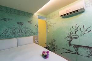 a bedroom with a bed with a deer painted on the wall at Morwing Hotel - Culture Vogue in Taipei