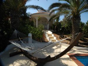 a hammock in front of a house with palm trees at Oasi Di Casablanca in Lampedusa