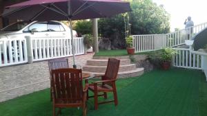 a table with two chairs and an umbrella on a lawn at SHAY LYAH SELF CATERING in Victoria