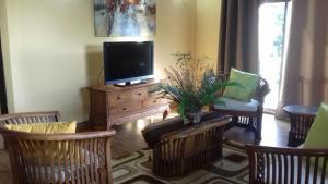 a living room with a flat screen tv and chairs at SHAY LYAH SELF CATERING in Victoria