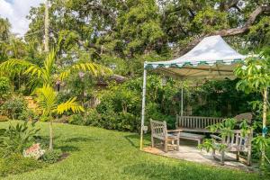 a bench under a gazebo in a garden at Floral Oasis in Fort Lauderdale