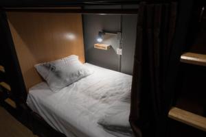 a bed with white sheets and pillows in a room at Comfy Bed Hostel in Bangkok +23 photos