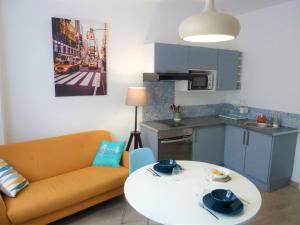 a living room with a couch and a table and a kitchen at Sémard in Brive-la-Gaillarde
