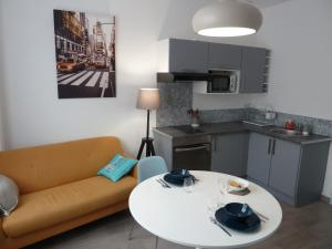 a living room with a couch and a table and a kitchen at Sémard in Brive-la-Gaillarde