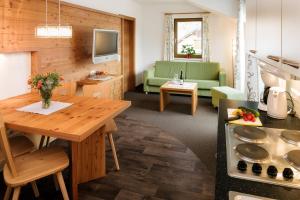 a kitchen and living room with a table and a couch at Apart Rubin in Serfaus