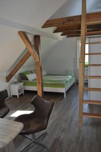 a bedroom with a bunk bed and a table and chairs at Gästehaus Am Wald Oschersleben in Oschersleben