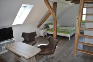 een kamer met een bed en een tafel en stoelen bij Gästehaus Am Wald Oschersleben in Oschersleben