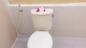 a white toilet with a toy on top of it at Lia Jaya Bungalows in Gili Meno