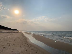 uma praia com o sol nascendo sobre o oceano em Apartamenty na Fali em Mrzeżyno