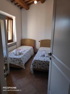 Pokój z 2 łóżkami, oknem i drzwiami w obiekcie IMMERSA NEL VERDE w mieście Osimo