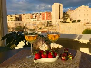 two glasses of wine and strawberries on a table at Vista Suites - Piazza Yenne in Cagliari
